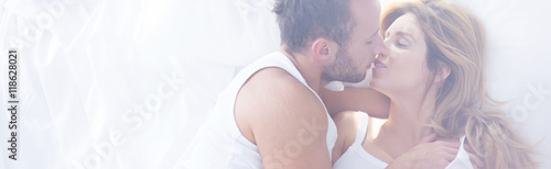 Romantic couple kissing in bed