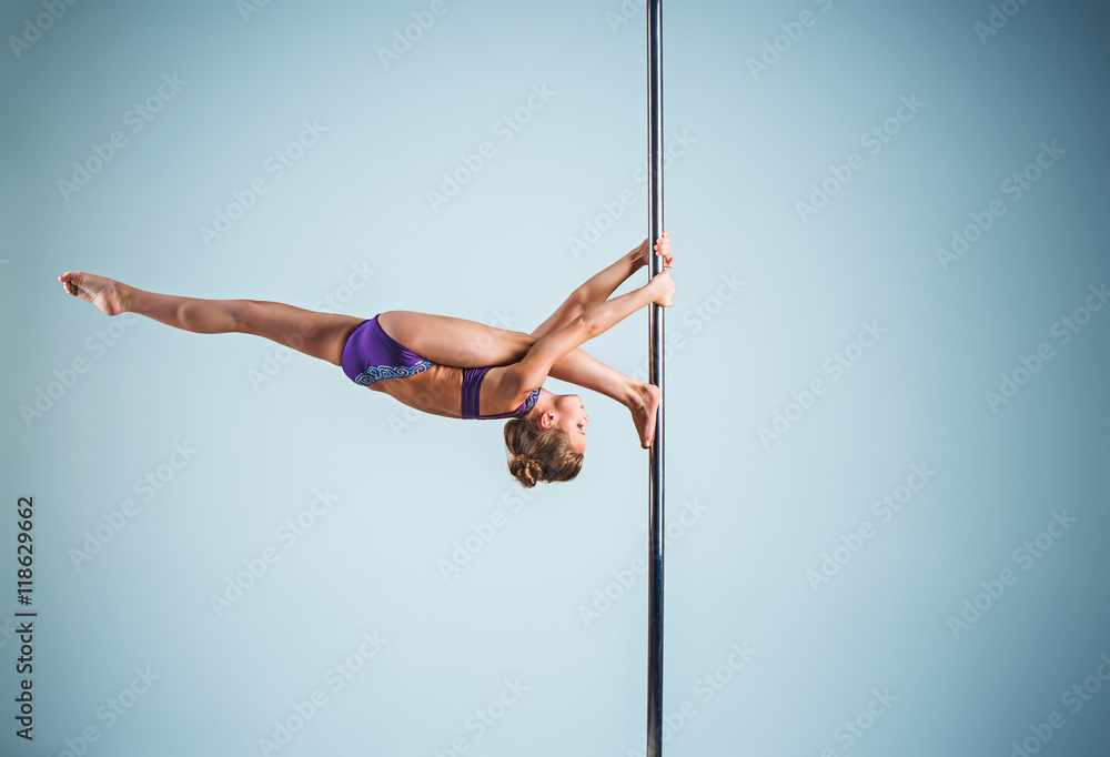 The strong and graceful young girl performing acrobatic exercises on pylon The strong and graceful young girl performing acrobatic exercises on pylon