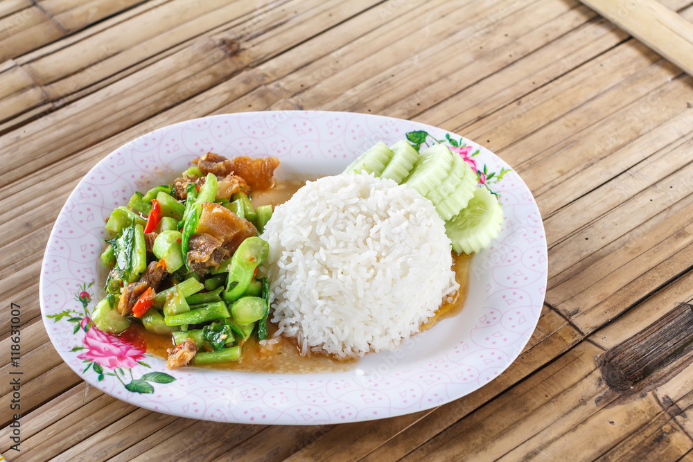 Stir fried kale with crispy pork with rice on wood background. Crispy Pork with Kale Thai food. Asian style food. Stir fried kale with crispy pork with rice on wood background. Crispy Pork with Kale Thai food. Asian style food.