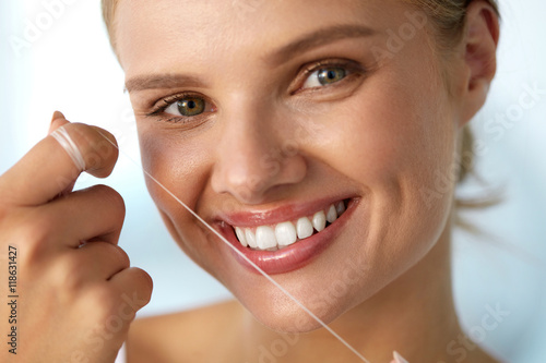 Dental Health. Woman With Beautiful Smile Flossing Healthy Teeth. High Resolution Image