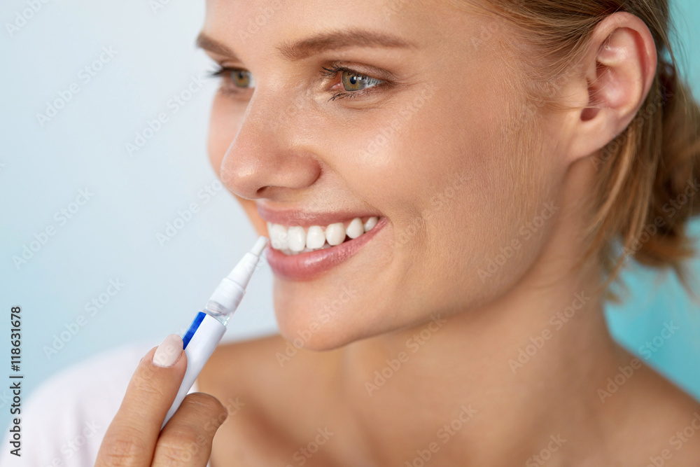 Healthy White Teeth. Beautiful Smiling Woman Using Whitening Pen. High Resolution Image