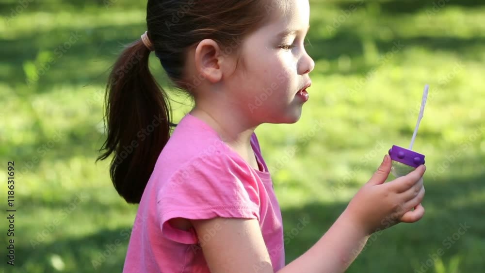 Happy child blowing soap bubbles in summer park Happy child blowing soap bubbles in summer park
