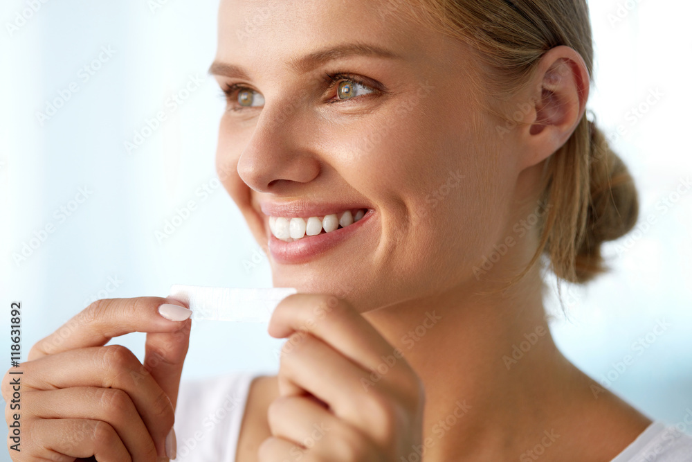 Woman With Healthy White Teeth Using Teeth Whitening Strip. High Resolution Image Woman With Healthy White Teeth Using Teeth Whitening Strip. High Resolution Image