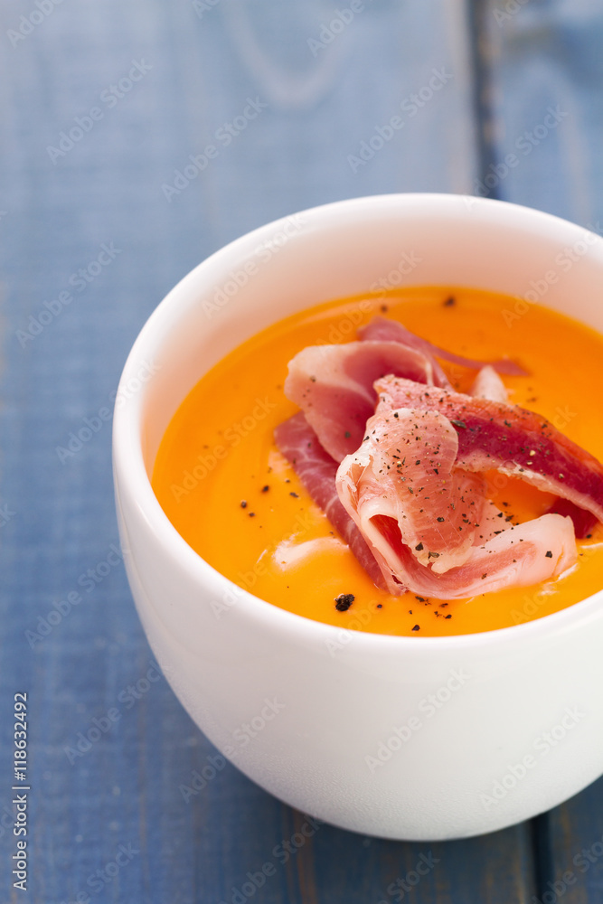 cold soup with smoked meat in white cup on blue wooden background cold soup with smoked meat in white cup on blue wooden background