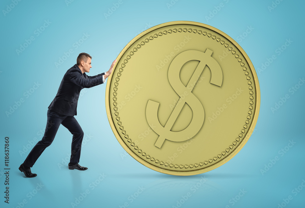 Businessman rolling big golden dollar coin Businessman rolling big golden dollar coin