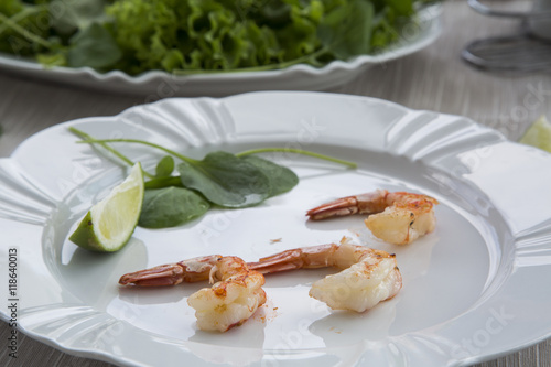 Fried shrimp with lemon on a white plate oven old wooden backgro