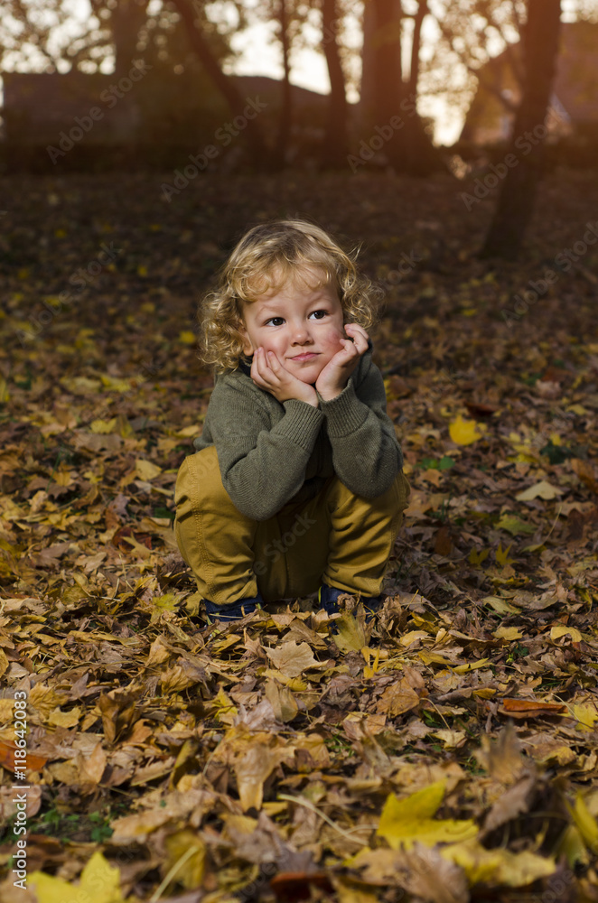 Adorable kid making cute face in park in autumn Adorable kid making cute face in park in autumn