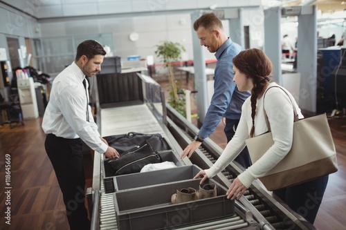 Woman putting shoes into tray for security check