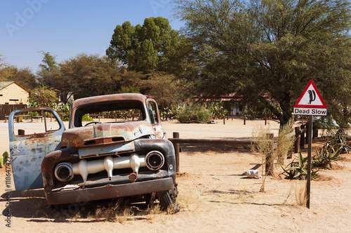 Old rusty car and road sign in Solitaire, Namibia; Concept for travel in Africa