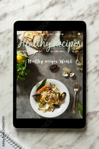 Tablet With healthy recipes blog on screen. web with nutritious photo