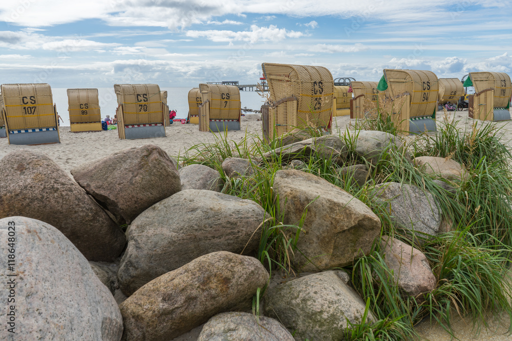 Strandkörbe und Findlinge zwischen Dünengras und blauem Meer Strandkörbe und Findlinge zwischen Dünengras und blauem Meer