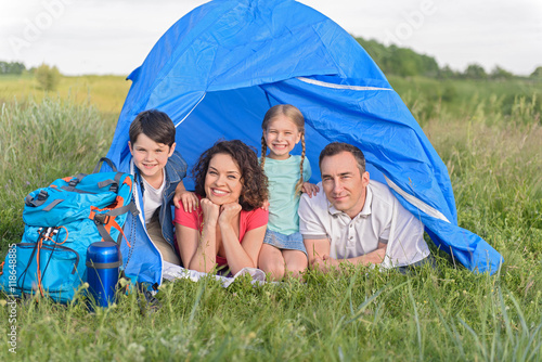 Happy family lying in tent