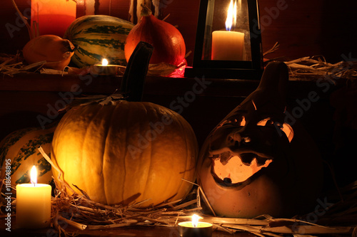 Halloween pumpkins with lantern and candles on wooden staircase, dark background 