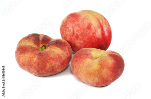 Nectarine and two flat peaches on white background