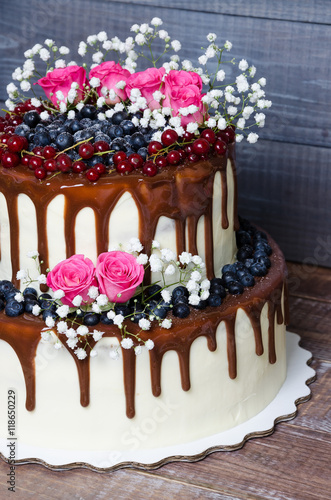 two layered color drip wedding cake with bilberries, red currant