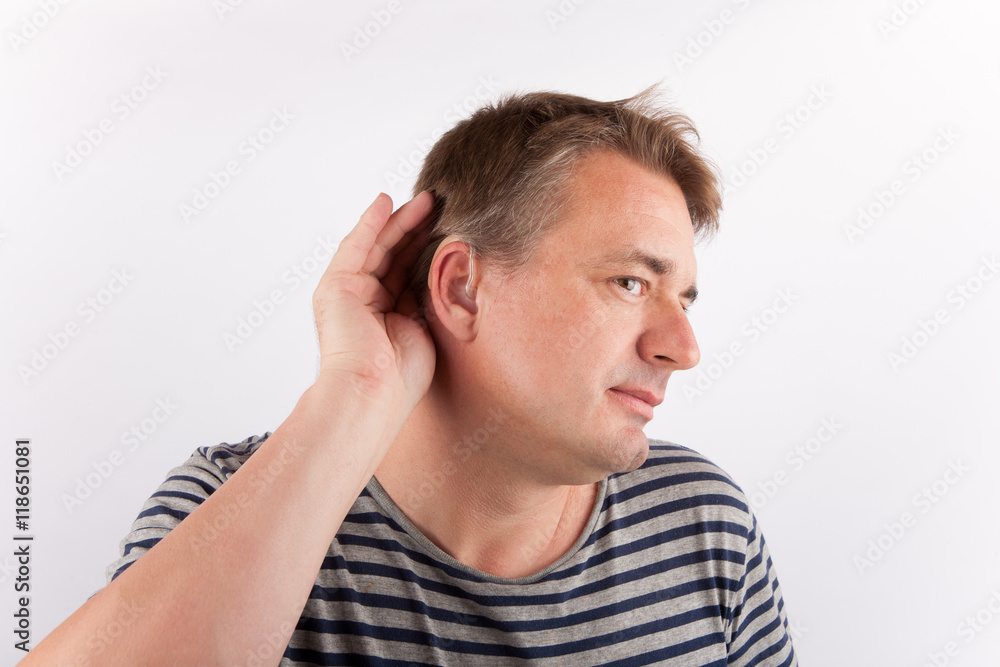 Senior man wearing hearing aid cupping his ear having difficulty hearing Senior man wearing hearing aid cupping his ear having difficulty hearing