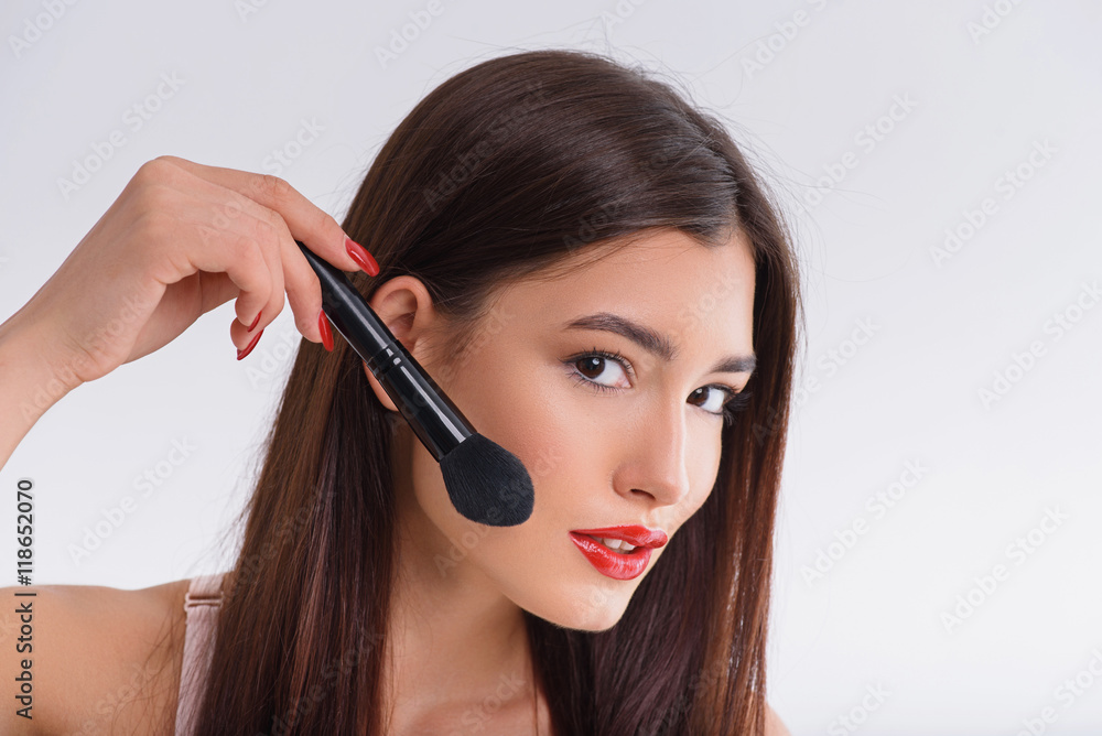Cheerful young woman doing make-up Cheerful young woman doing make-up