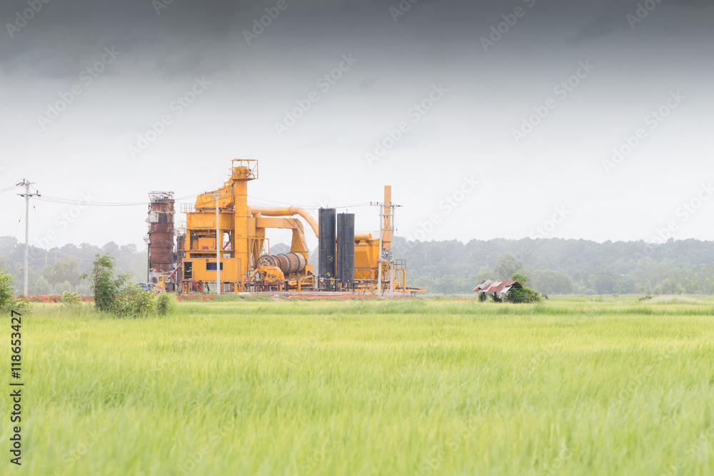 Obraz premium Industrial chimneys of a chemical factory in the middle of a gre