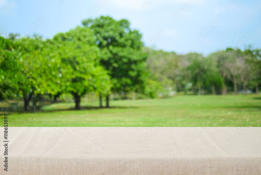 Empty table with linen tablecloth over blur park  background