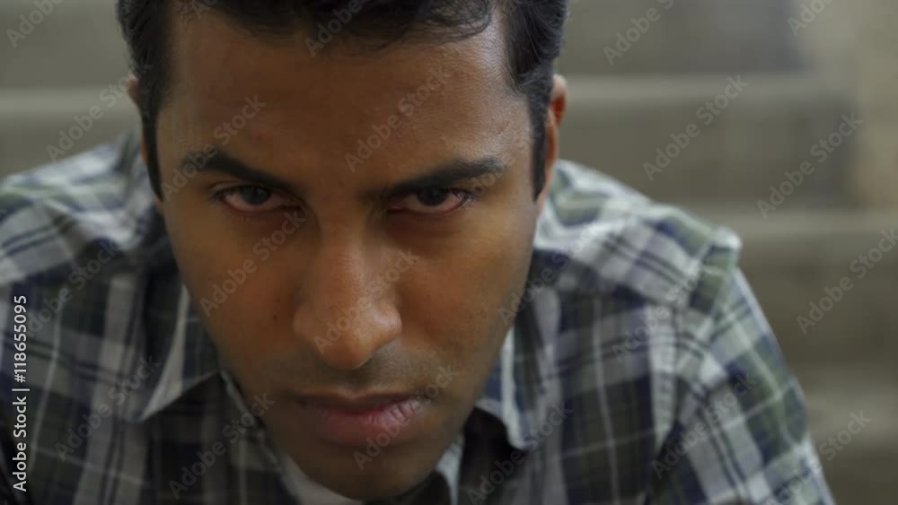 Upset young male of Indian ethnicity looking into camera. Upset young male of Indian ethnicity looking into camera.