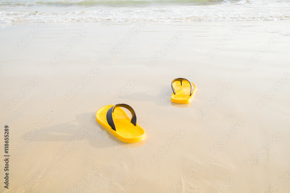 Obraz premium yellow sandals on the beach at the vacation or relax time