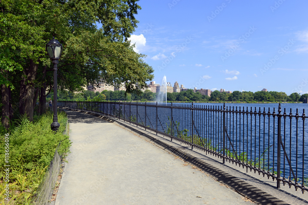 Central Park reservoir with fountain with Upper West Side skyline and blue sky with clouds, Manhattan, New York City Central Park reservoir with fountain with Upper West Side skyline and blue sky with clouds, Manhattan, New York City
