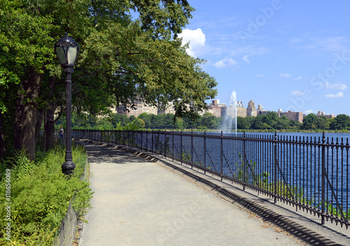 Central Park reservoir with fountain with Upper West Side skyline and blue sky with clouds, Manhattan, New York City photo