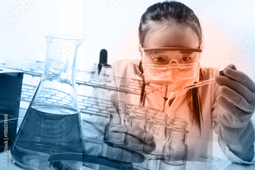 female medical or scientific researcher or woman doctor looking at a test tube of clear solution in a laboratory