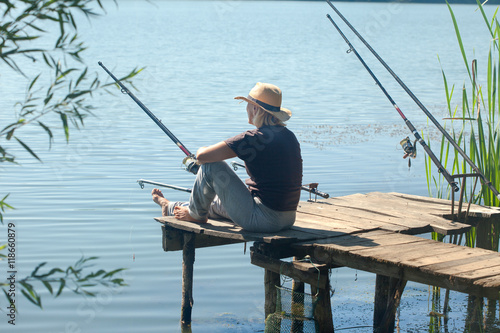 Older woman relaxing and fishing on the lake in a summer day
