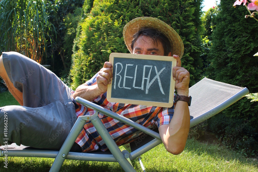 Mann im Liegestuhl,Garten hält Tafel mit "Relax" Stock-Foto | Adobe Stock