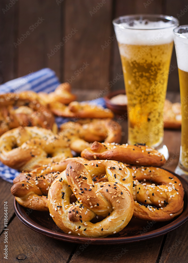 Oktoberfest salted soft pretzels in a bowl and beer from Germany on wooden background.