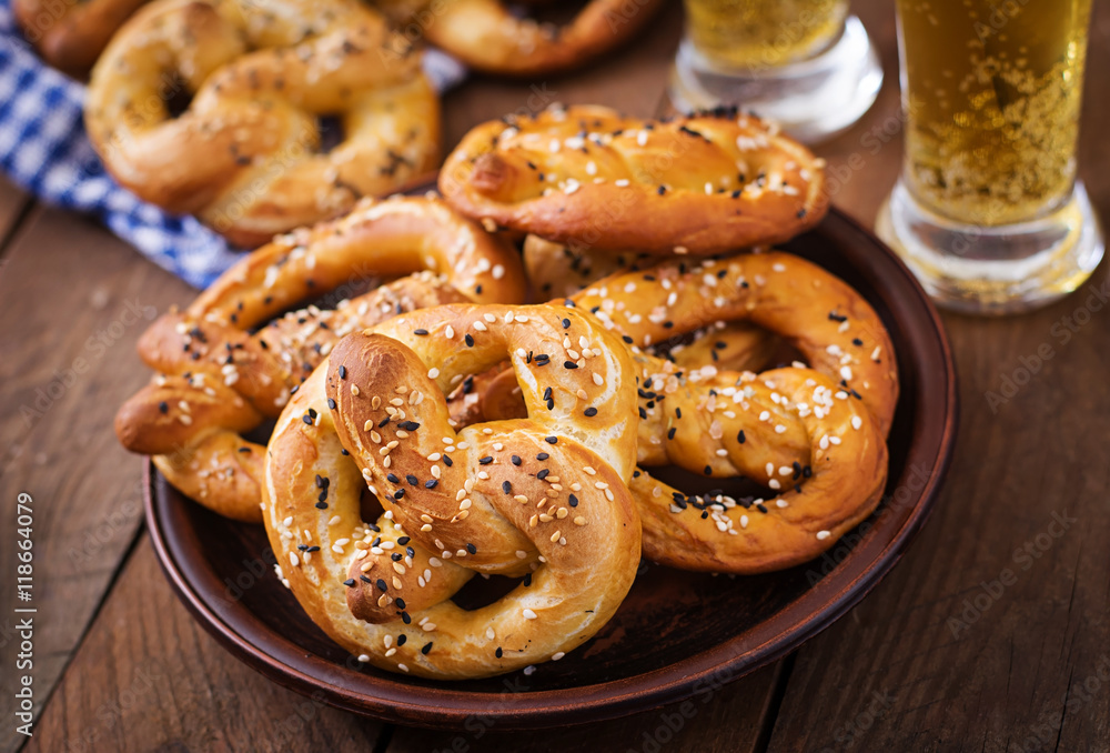 Oktoberfest salted soft pretzels in a bowl and beer from Germany on wooden background. Oktoberfest salted soft pretzels in a bowl and beer from Germany on wooden background.
