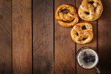 Oktoberfest salted soft pretzels and beer from Germany on wooden background. Top view