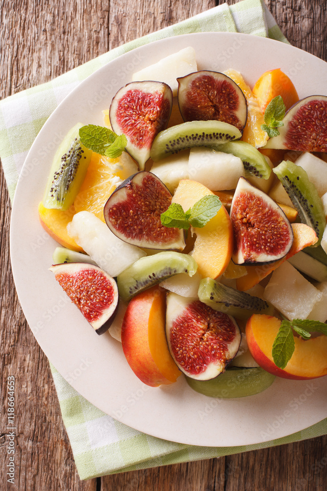 Sliced fresh fruit: figs, peaches, melons, kiwi and orange close-up. vertical top view
Sliced fresh fruit: figs, peaches, melons, kiwi and orange close-up. vertical top view
