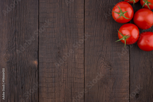 Fresh tomatoes on rustic wooden background.