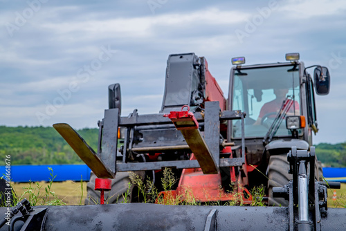 Loader in the field on a background cloudy sky. photo