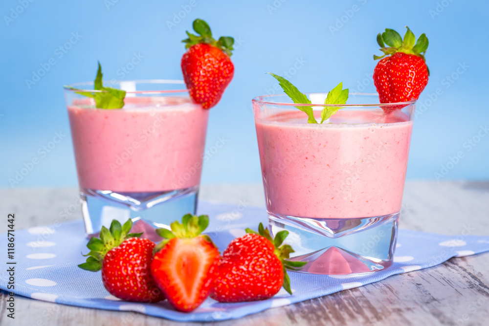 Glasses of strawberry smoothie on wooden table Glasses of strawberry smoothie on wooden table