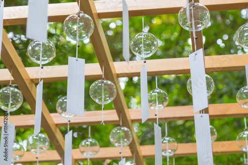 Clear glass wind chimes hang from wood structure during Wind Chi