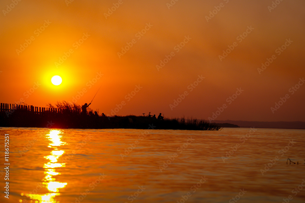 Man fish at sunset