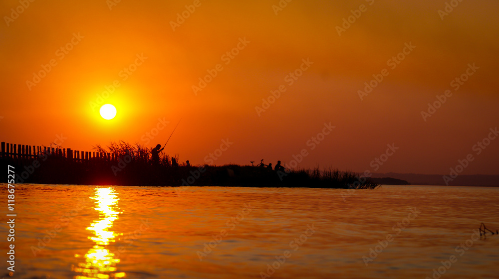 Man fish at sunset