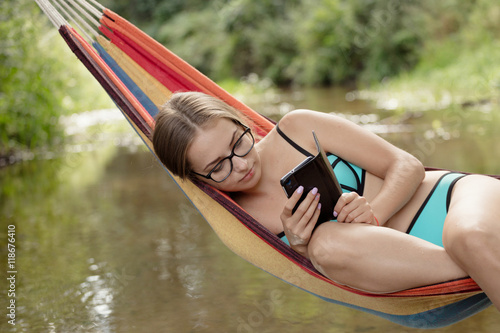 girl in a hammock with a phone in his hand photo