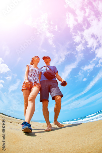 couple walking on the sunny beach at the sunrise. Area Chania city, Crete, Greece.