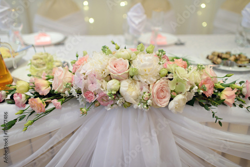 Fototapeta Naklejka Na Ścianę i Meble -  Beautiful wedding restaurant for marriage. White decor for bride and groom. Colorful decoration for celebration. Beauty bridal interior. Bouquet, food and flowers in hall