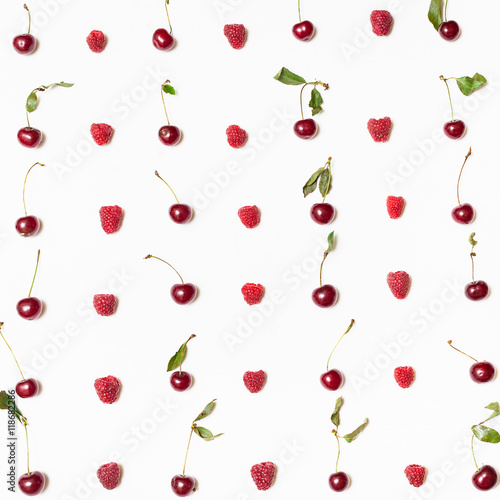 many raspberries and cherries arranged on square