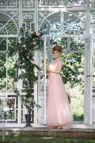 Beautiful bride in long pink dress with bright terrace