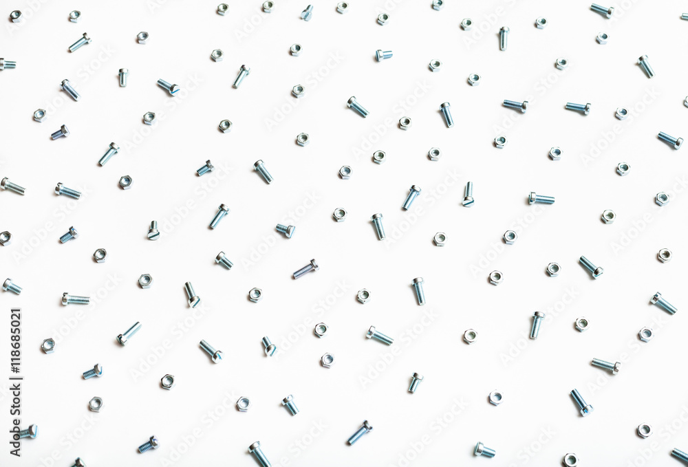 above view of many steel bolts and nuts on white above view of many steel bolts and nuts on white