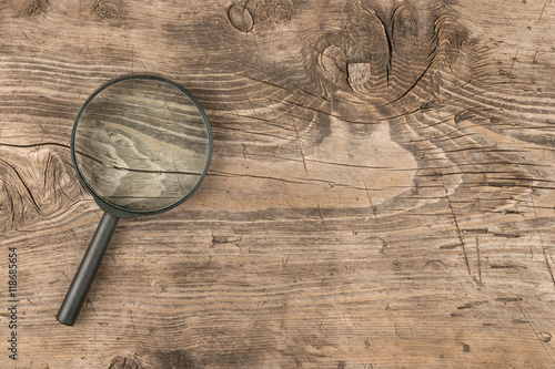 Magnifying glass lying on a wooden surface