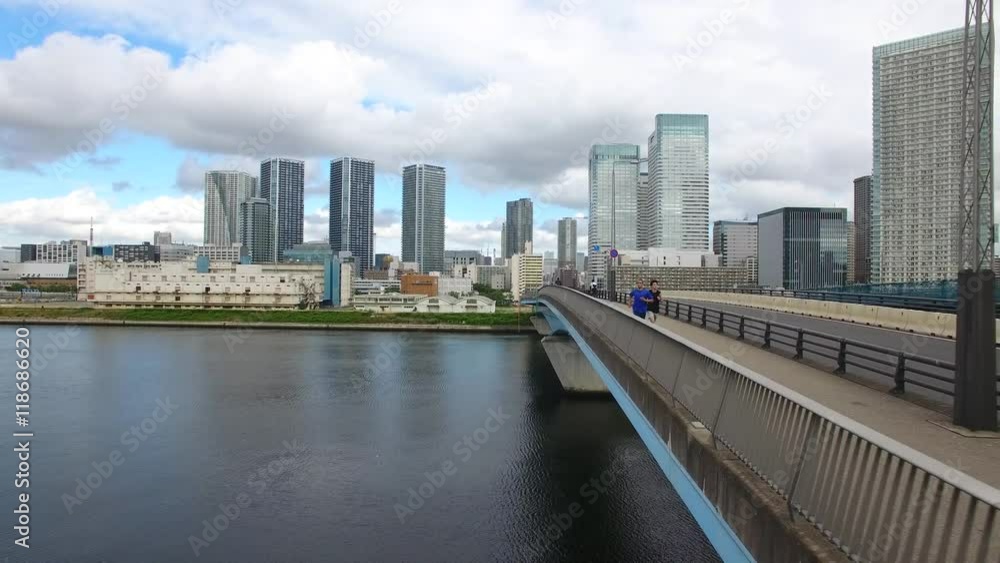 Caucasion and Japanese fitness training on bridge Tokyo Drone aerial shot Caucasion and Japanese fitness training on bridge Tokyo Drone aerial shot