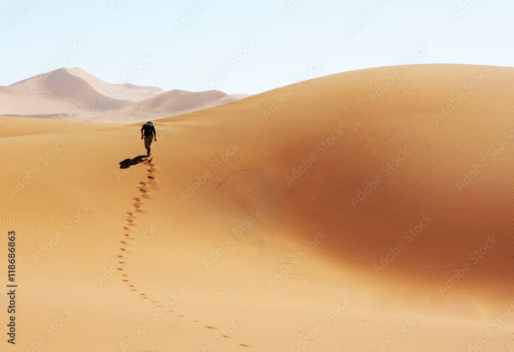 Mann laeuft durch die Wüste von Namibia - obrazy, fototapety, plakaty 