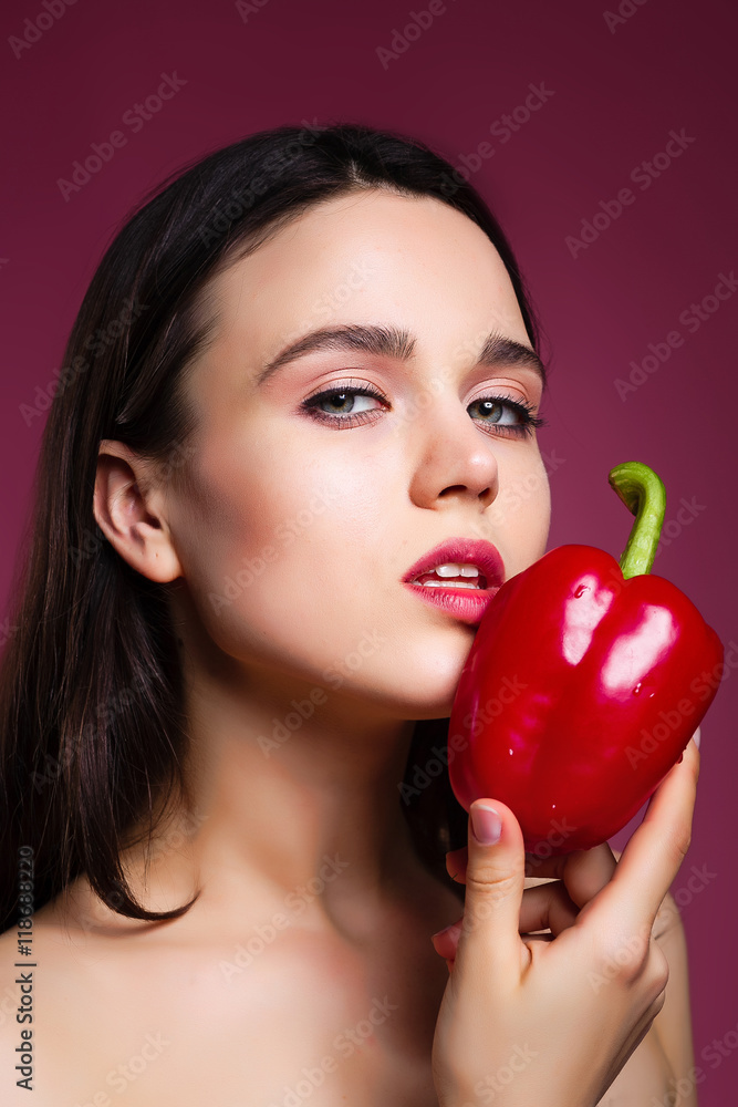 beautiful girl in the studio on a pink background with pepper. t beautiful girl in the studio on a pink background with pepper. t